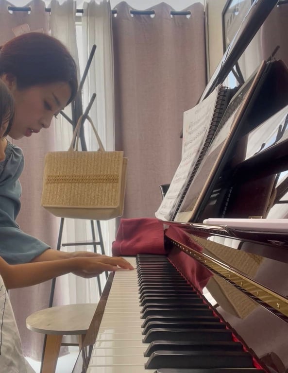 Sera Yoon guiando a una alumna durante una clase de piano en el estudio de Mérida