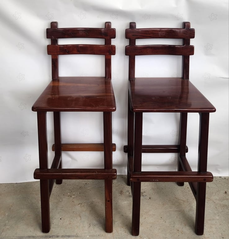 A pair of vintage solid dark wood bar stools