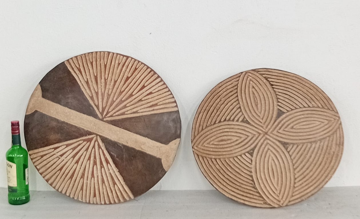 A pair of hand-carved round wooden wall panels