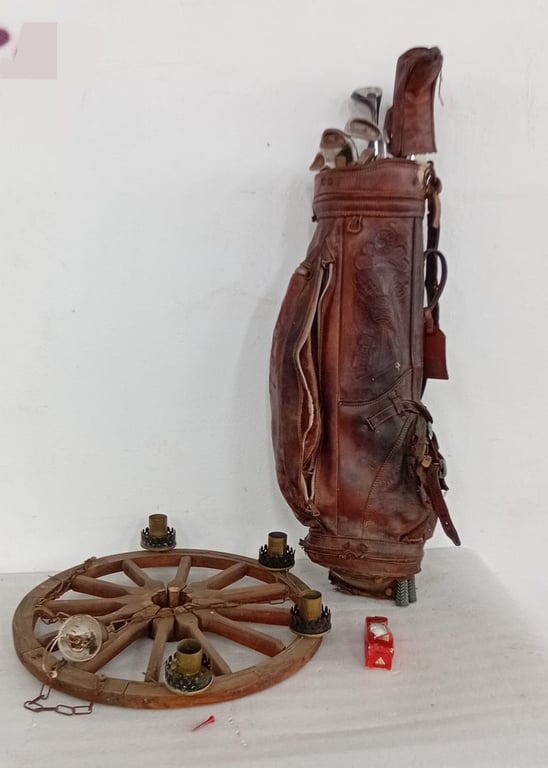 A mixed vintage lot comprising a leather golf bag with clubs and a rustic wooden wagon-wheel style candle holder.