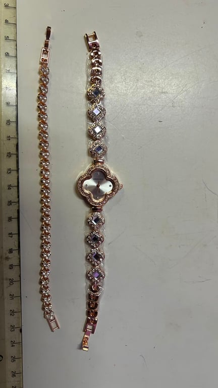 This rose gold bracelet watch features a four leaf clover design with crystal details