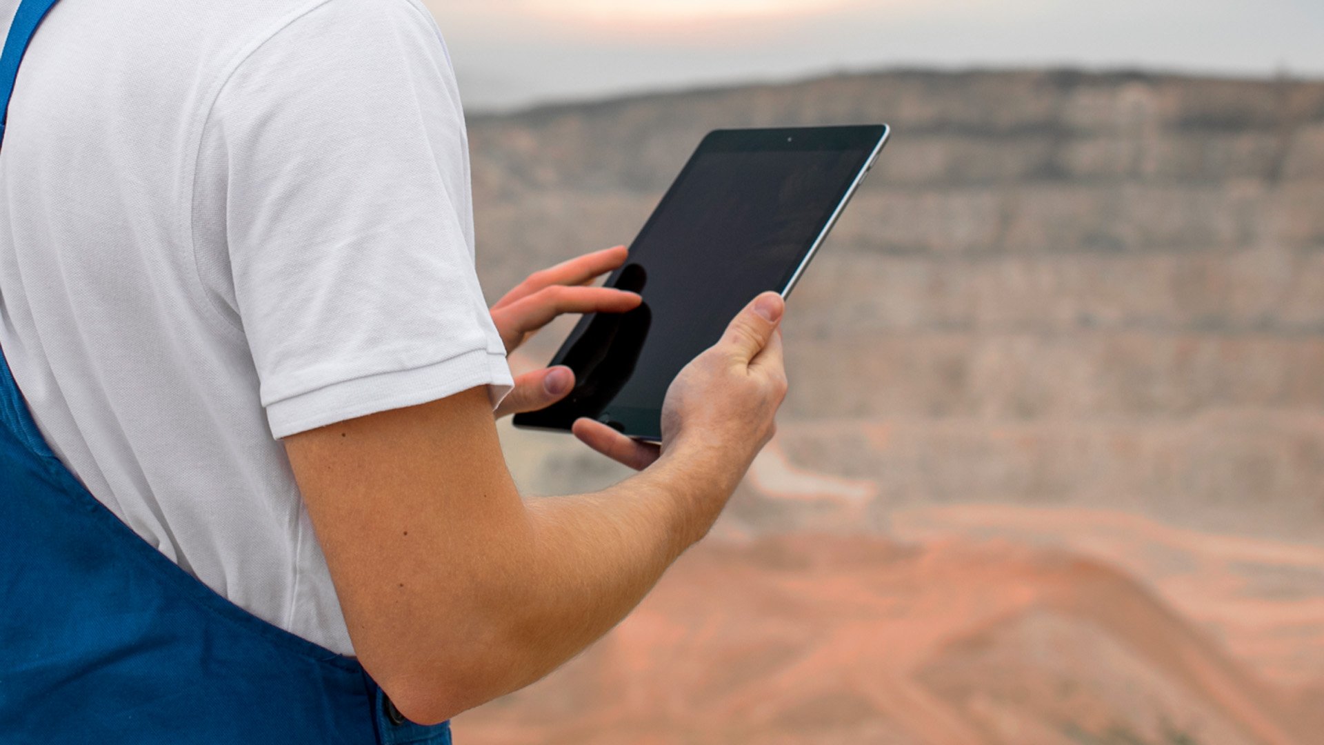 A worker at Heathgate Resources' mine site checks network status on a tablet.