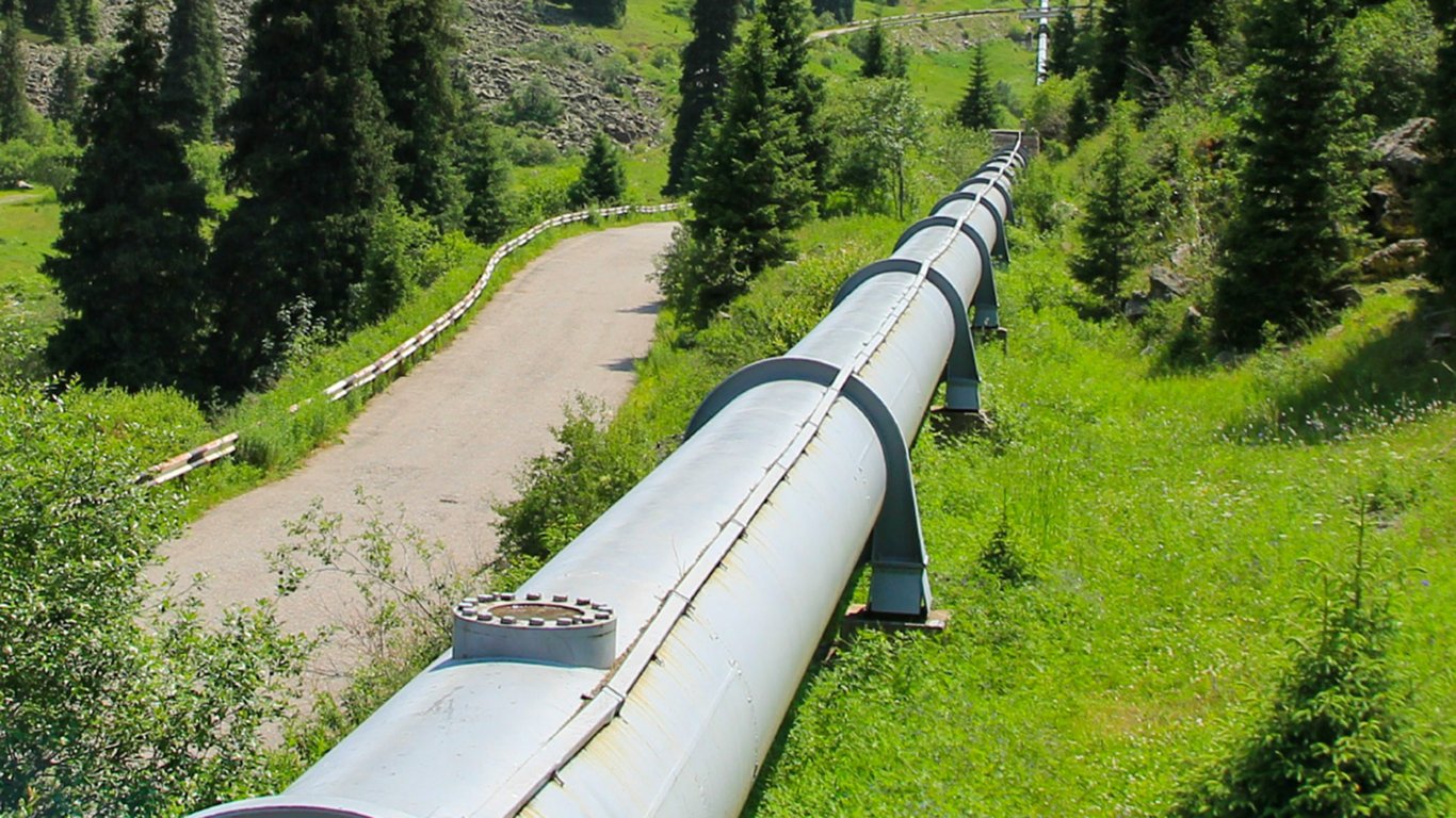 Industrial pipeline running through a forested landscape representing Peplink utilities and energy case studies.
