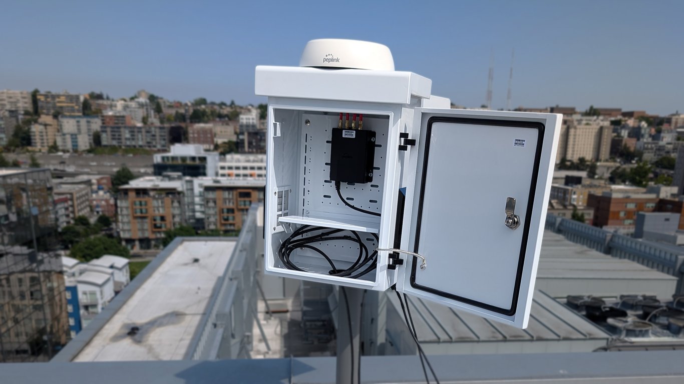 Peplink router installed in an enclosure on a rooftop for private 5g site connectivity.