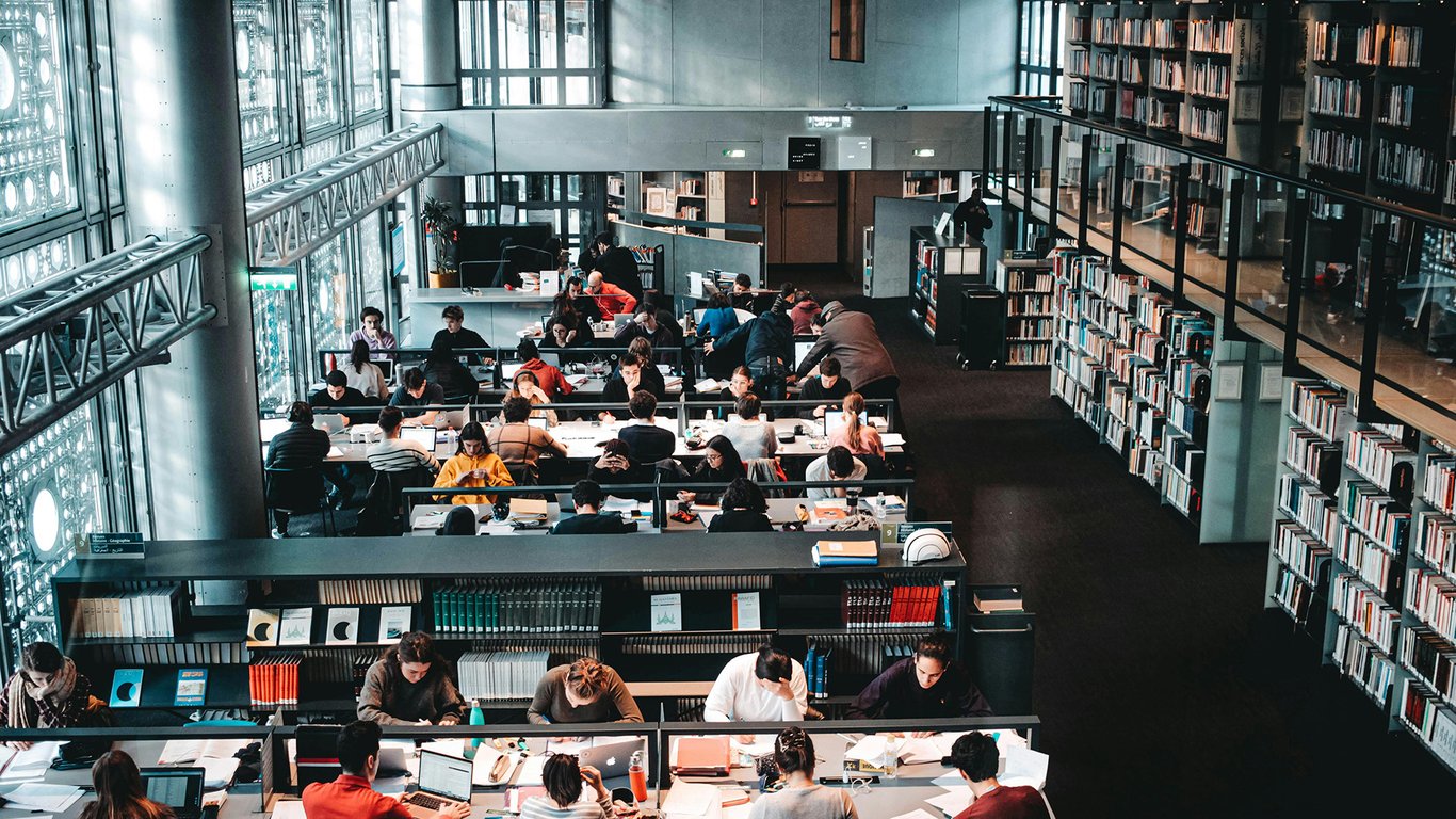 University library with students working representing Peplink education connectivity solutions.