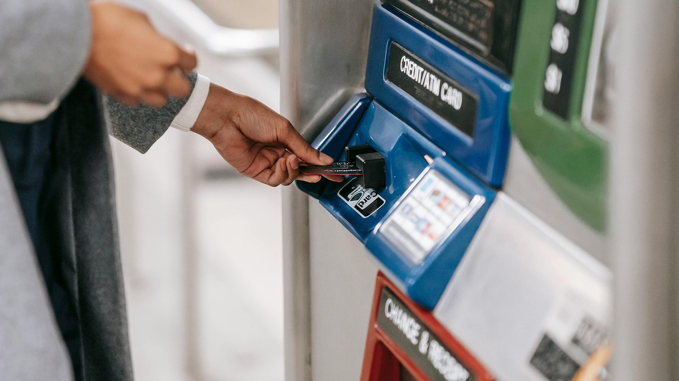 Person inserting card into an ATM representing Peplink finance connectivity solutions.