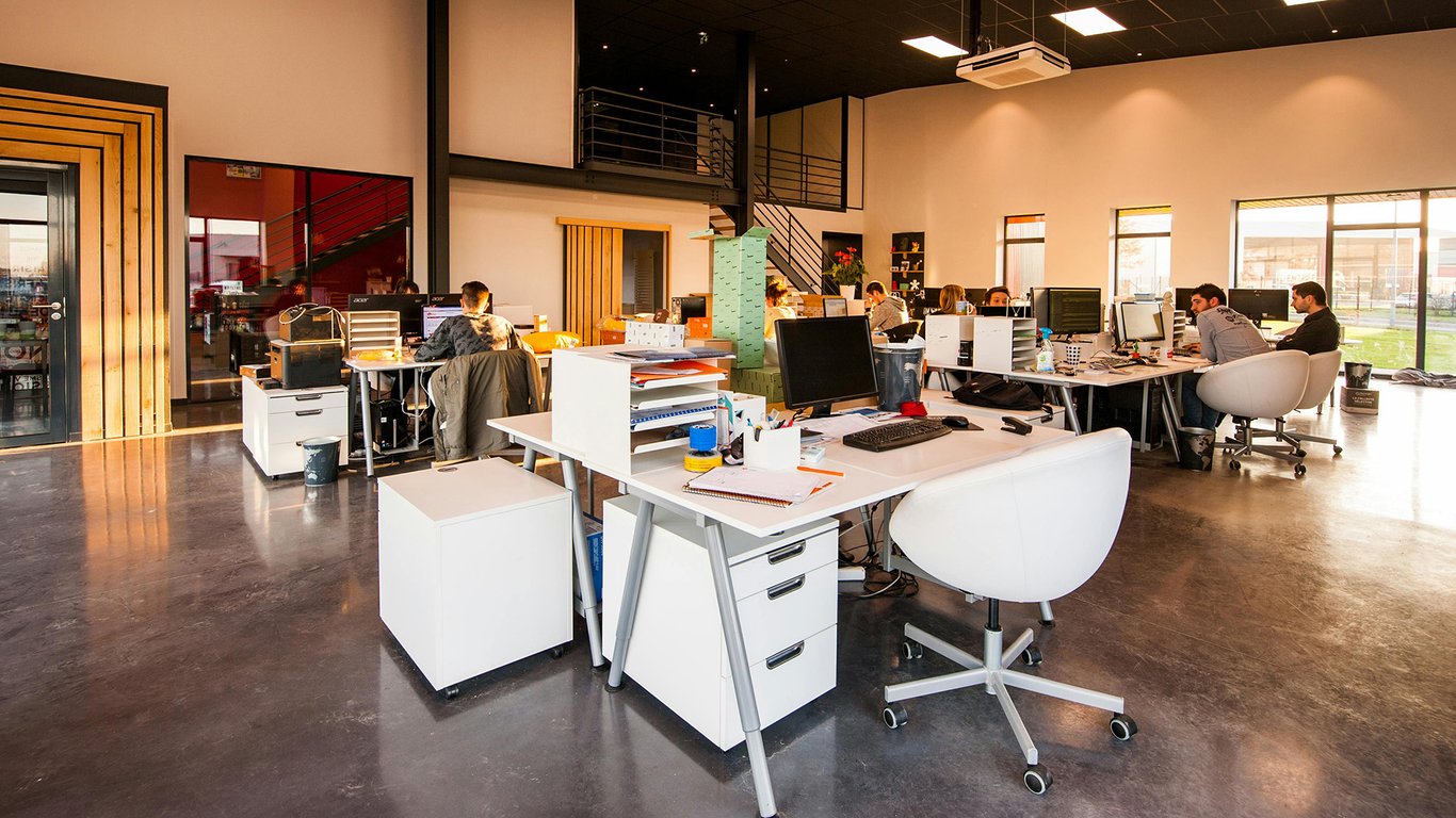 Open plan office with employees at workstations representing Peplink SME connectivity solutions.