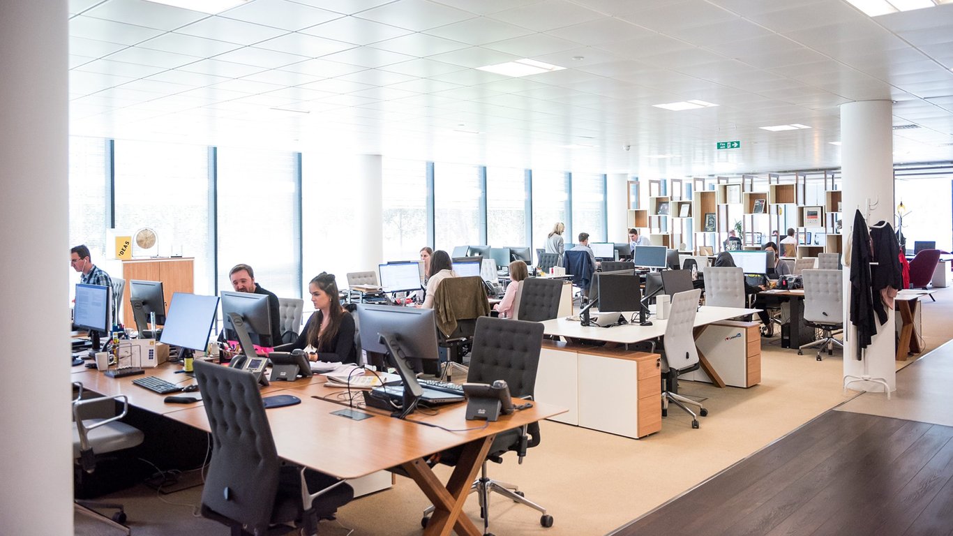 Open plan office with employees at workstations representing Peplink enterprise branch connectivity.