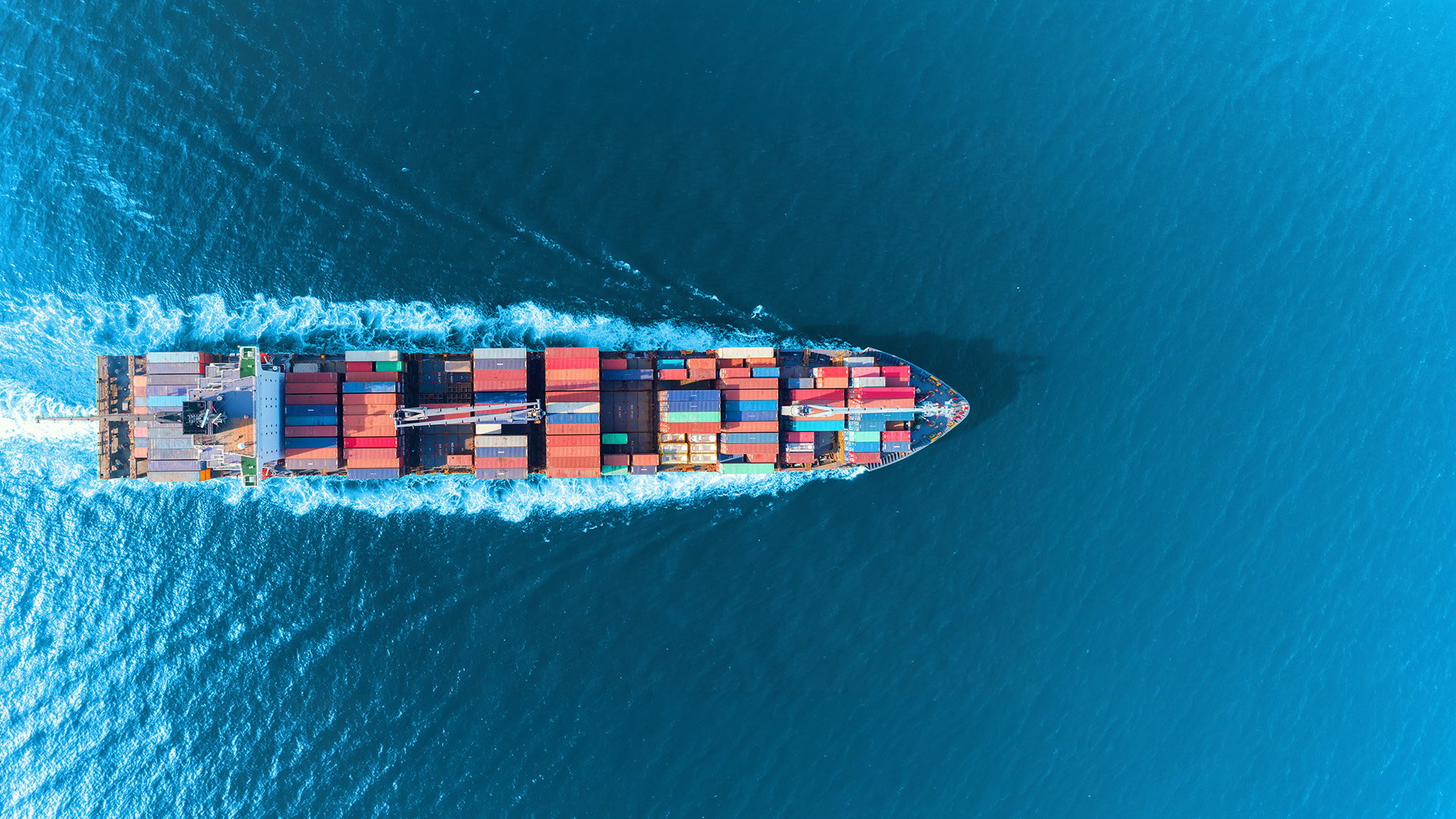 Aerial view of a container ship at sea representing Peplink mobile bandwidth bonding for maritime connectivity.