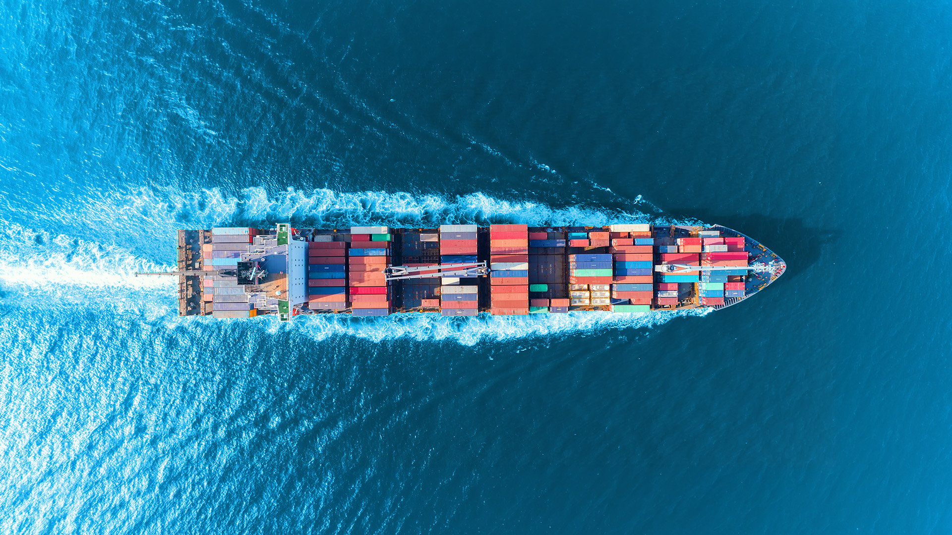 Aerial view of a container ship at sea representing Peplink mobile bandwidth bonding for maritime connectivity.