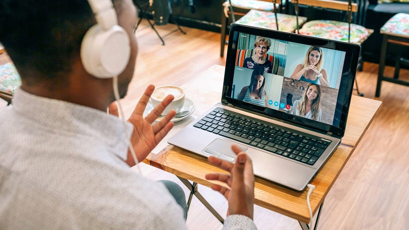 Person on a video call using a laptop with headphones representing Peplink unbreakable VoIP connectivity.