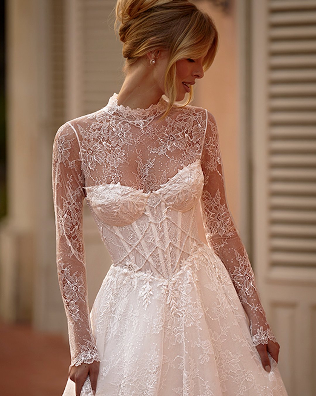 Elegancka suknia ślubna Lazurina zachwyca romantyczną linią A, pełną koronkowych detali i subtelnego blasku. Gorsetowy fason w połączeniu z dopinanym bolerkiem tworzy efektowną, a zarazem delikatną stylizację. To idealna propozycja dla Panny Młodej, która ceni klasykę w nowoczesnym wydaniu...