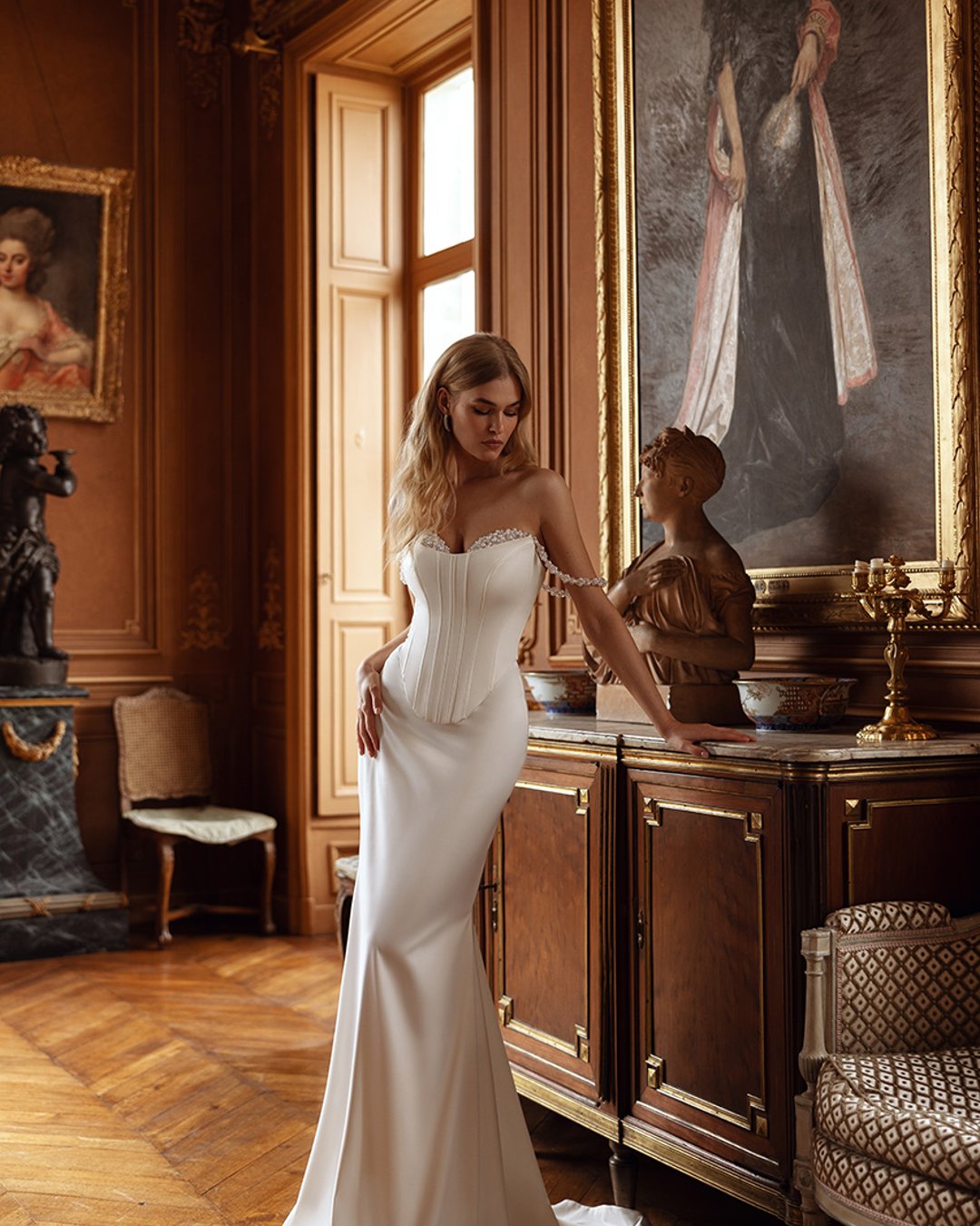 Brava to wyjątkowa kreacja, która wyróżnia się eleganckim krojem i wszechstronnością. Model oferuje dwa style spódnicy – klasyczną princesskę oraz dopasowaną rybkę. Gorset wyszywany kryształkami i perłami dodaje blasku, a subtelne opadające rękawki nadają lekkości. Suknia z efektywnym rozcięciem na nogę, wykonana z wysokiej jakości satyny, zapewnia komfort i doskonały wygląd przez cały dzień.