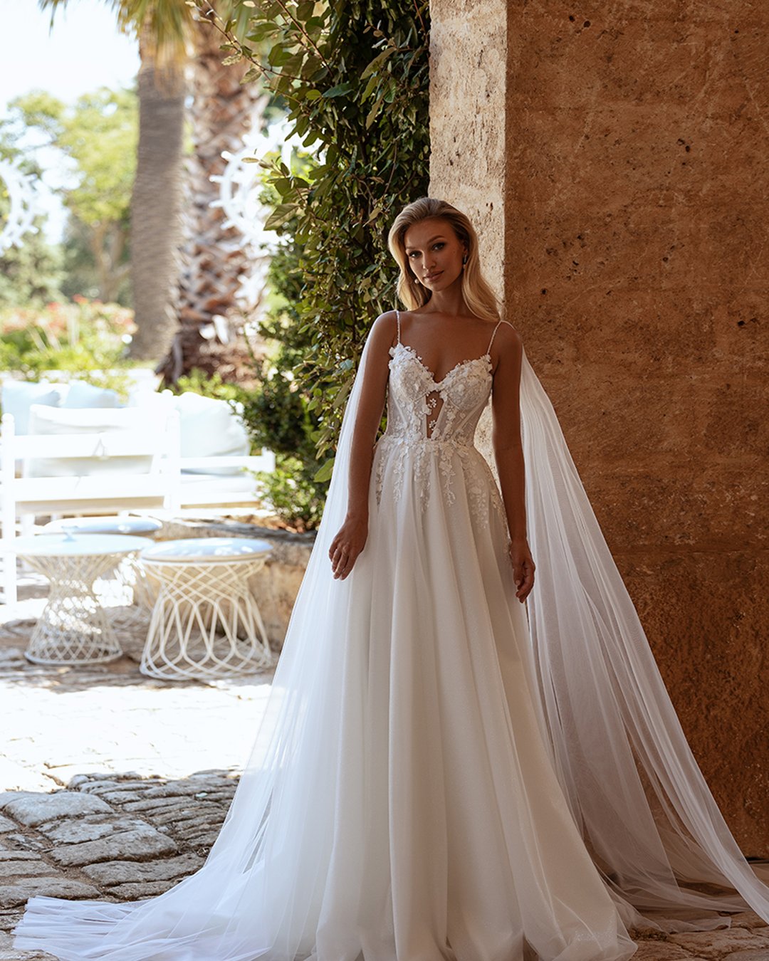 Model Avva, wykonana z lekkiego tiulu i koronki, o kroju litery A z kwiatkami 3D i trenem. Idealna dla panny młodej szukającej elegancji i subtelności.