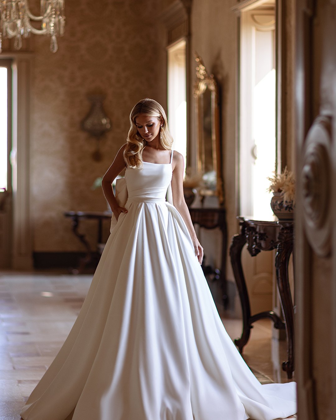 Anna Sposa – Model Sonet, gorsetowa princesska z matowej satyny, z odpinanymi ramiączkami, przeźroczystymi plecami, kokardą i trenem. Minimalistyczna elegancja na Twój wielki dzień!