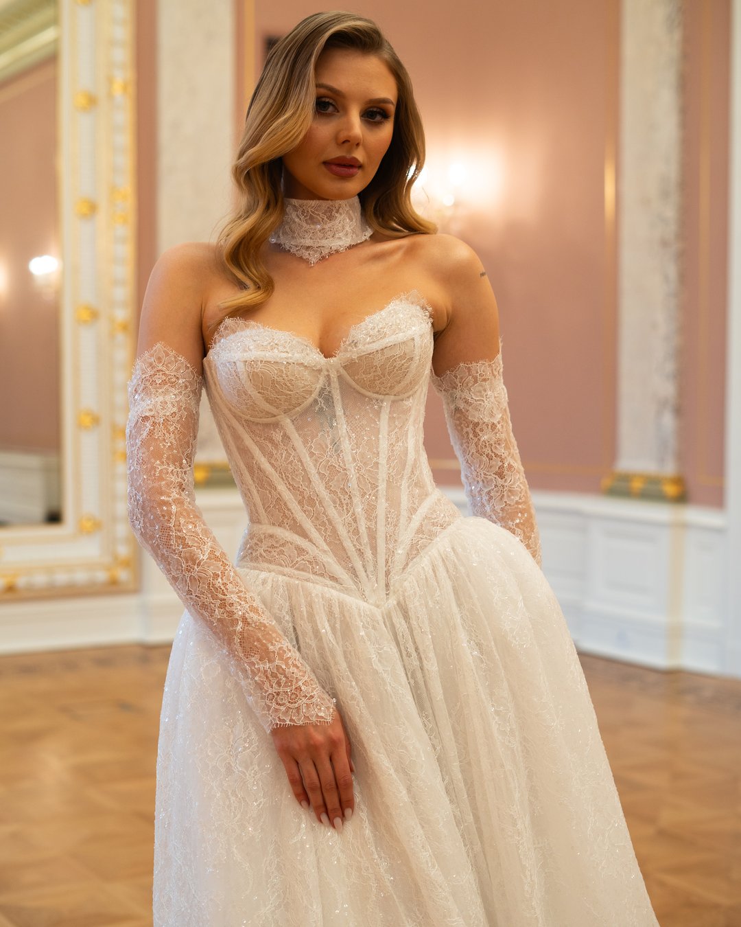 Suknia ślubna Lora z kolekcji LaLiven to prawdziwy symbol nowoczesnej elegancji, łączący w sobie styl princessy i linię A. Jej zachwycający gorset ozdobiony francuską koronką podkreśla sylwetkę, a delikatne, nakładane rękawki dodają subtelności. Długi tren sprawia, że każda panna młoda poczuje się niczym królowa w dniu swojego ślubu.