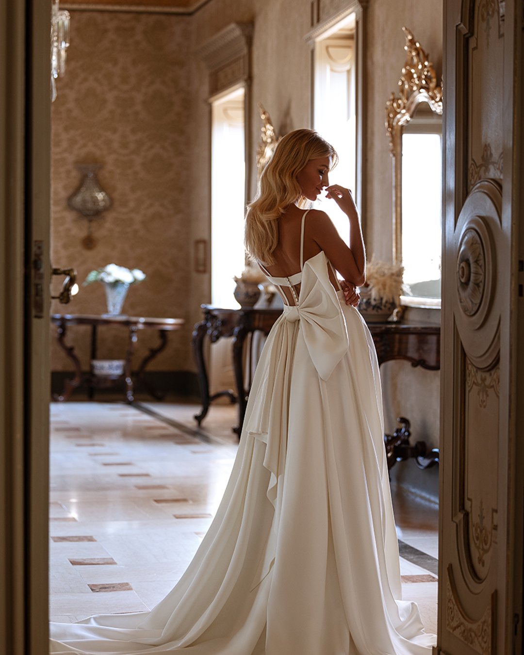 Anna Sposa – Model Sonet, gorsetowa princesska z matowej satyny, z odpinanymi ramiączkami, przeźroczystymi plecami, kokardą i trenem. Minimalistyczna elegancja na Twój wielki dzień!