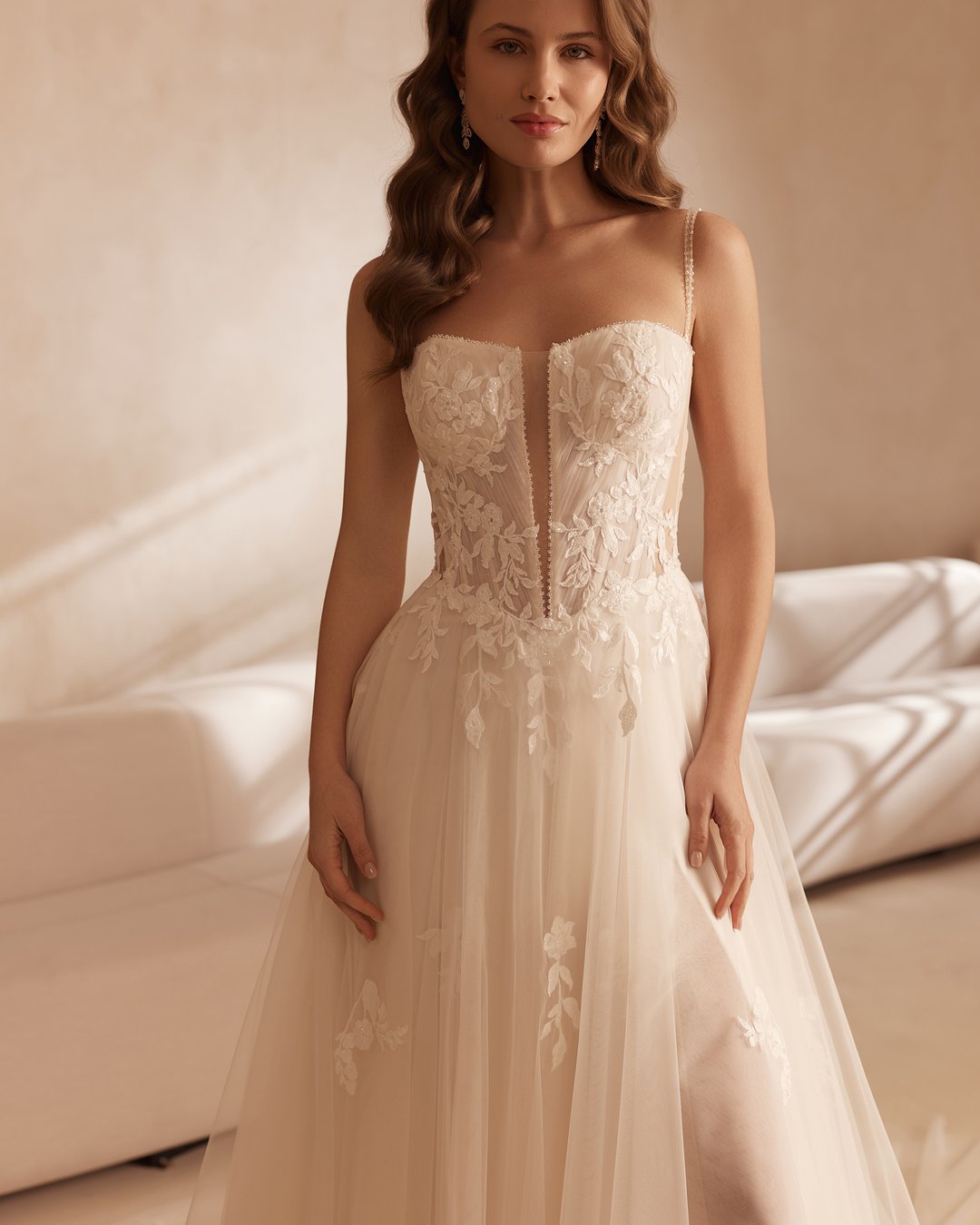 Suknia ślubna 5861 z kolekcji Elizabeth Passion to kwintesencja romantyzmu, łącząca delikatną koronkę i zwiewny tiul. Jej szeroka spódnica w linii A, na ramiączkach z subtelnym rozporkiem oraz gorsetowym pasem w kształcie litery V, podkreśla sylwetkę, a ozdobne kwiatki dodają jej wyjątkowego uroku. Ta elegancka suknia sprawi, że każda panna młoda poczuje się jak prawdziwa księżniczka w dniu swojego ślubu.