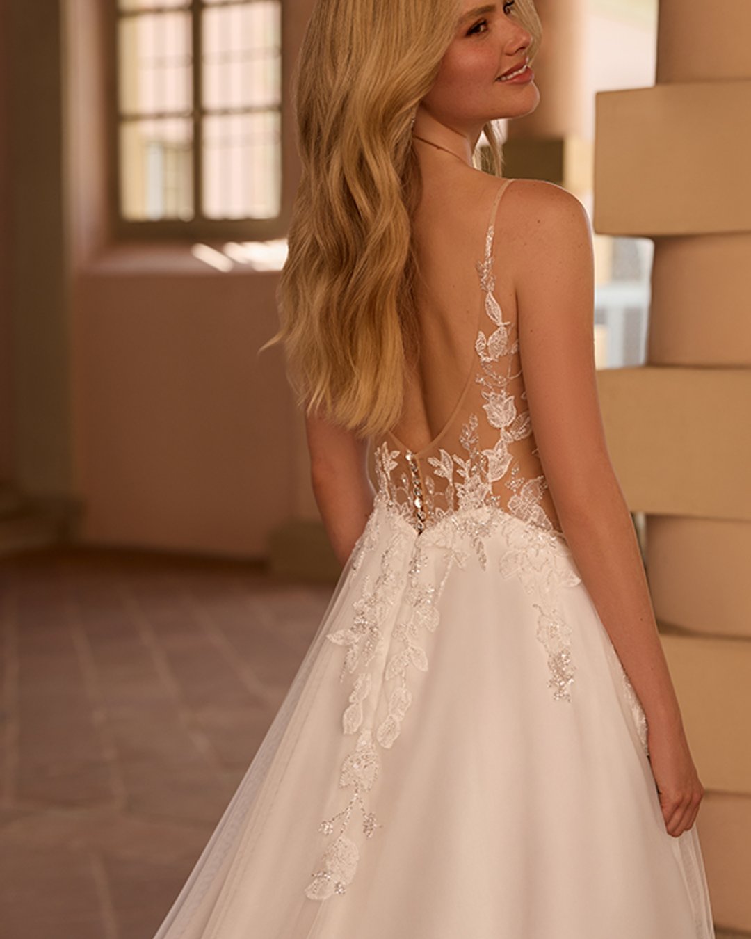 Model Setaria to delikatna i romantyczna suknia ślubna na cienkich ramiączkach, zachwycająca lekkością i kobiecym urokiem. Gorset z dekoltem w kształcie litery V oraz przezroczyste, błyszczące detale pięknie podkreślają sylwetkę, a szeroka, tiulowa spódnica w linii A nadaje kreacji zwiewności. Idealna propozycja dla Panny Młodej ceniącej klasyczną elegancję z nutą nowoczesności.