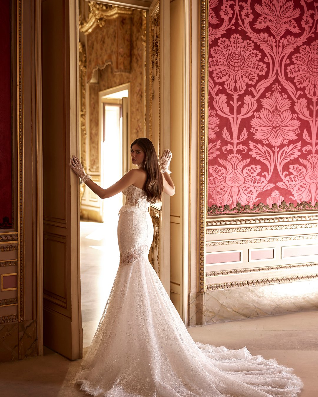 Suknia ślubna Litia z kolekcji AnnaSposa to prawdziwy manifest elegancji i nowoczesności, która zachwyci każdą pannę młodą. Wykonana z luksusowej francuskiej koronki, podkreśla sylwetkę w stylu syrenki dzięki dopasowanemu krojowi i zmysłowemu, przezroczystemu gorsetowi, a efektowny tren i baskinka dodają jej niepowtarzalnego uroku. Dodatkowe rękawiczki dopełniają ten wyjątkowy look, sprawiając, że każda chwila w tej sukni stanie się niezapomniana.