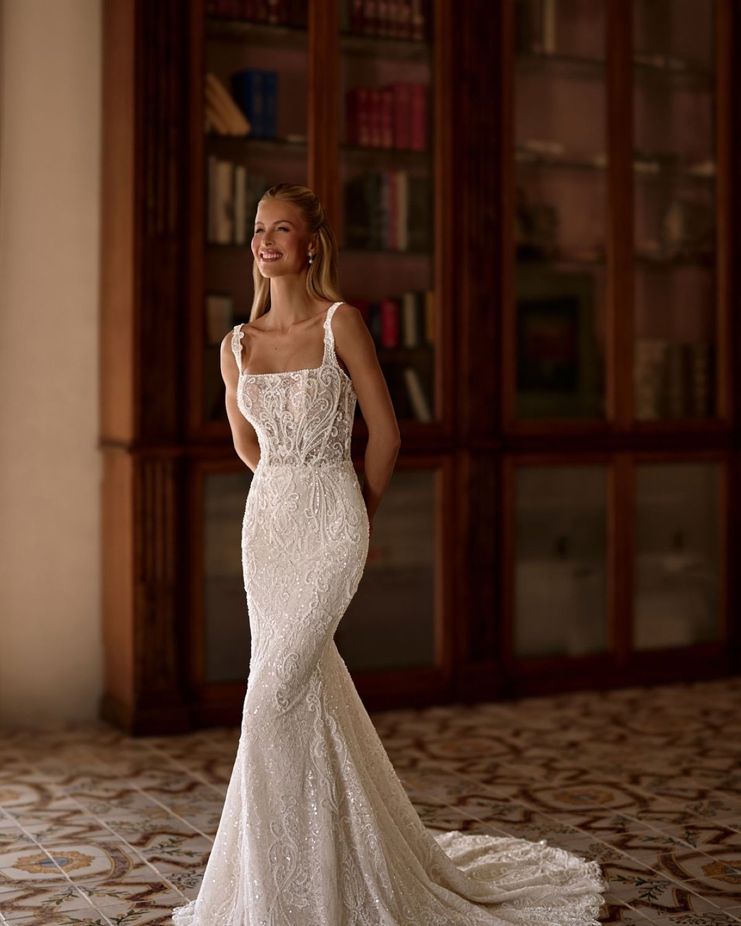 Suknia Tropikal od Anna Sposa to nowoczesna i elegancka propozycja o kroju tuba, wykonana z bogato zdobionej, ręcznie wyszywanej koronki. Zachwyca karo dekoltem, przezroczystą górą i subtelnym blaskiem. Dopasowany fason pięknie podkreśla sylwetkę, a całość emanuje szykiem i wyrafinowaniem.