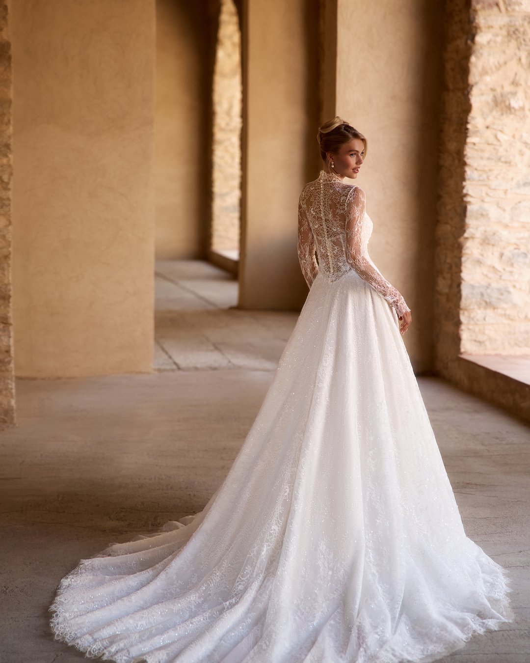Suknia ślubna Sirella z kolekcji AnnaSposa to kwintesencja romantyzmu, łącząca lekkość z elegancją. Jej rozkloszowany krój w linii A, podkreślający sylwetkę dzięki pasowi w kształcie litery V, współgra z delikatnym gorsetem i przezroczystym bolerkiem, natomiast francuska koronka dodaje jej wyjątkowego blasku. Z trenem, który subtelnie podkreśla każdy krok, Sirella sprawi, że każda panna młoda poczuje się jak prawdziwa księżniczka w swoim wyjątkowym dniu.