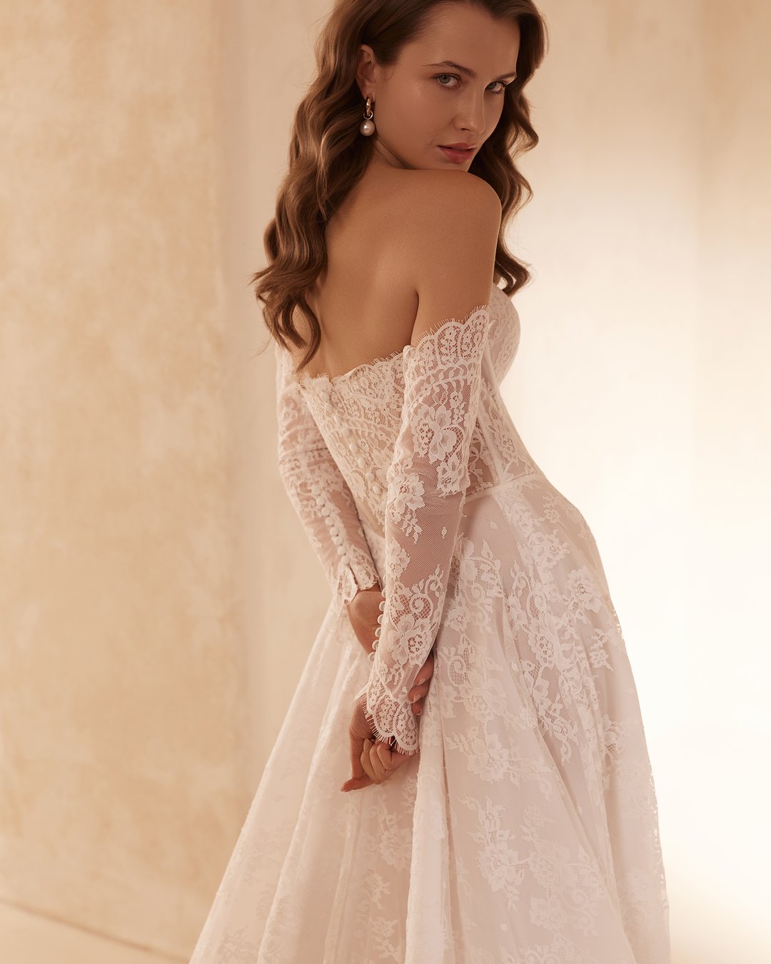 Suknia ślubna 5887 z kolekcji Elizabeth Passion to doskonałe połączenie klasyki z nowoczesnym stylem. Jej szeroka spódnica w linii A, ozdobiona delikatną francuską koronką, harmonijnie współgra z eleganckim gorsetem i przezroczystymi nakładanymi rękawami, tworząc niezapomniany look każdej panny młodej. Poczuj się wyjątkowo w tej sukni, która podkreśli Twoją urodę w najważniejszym dniu życia.