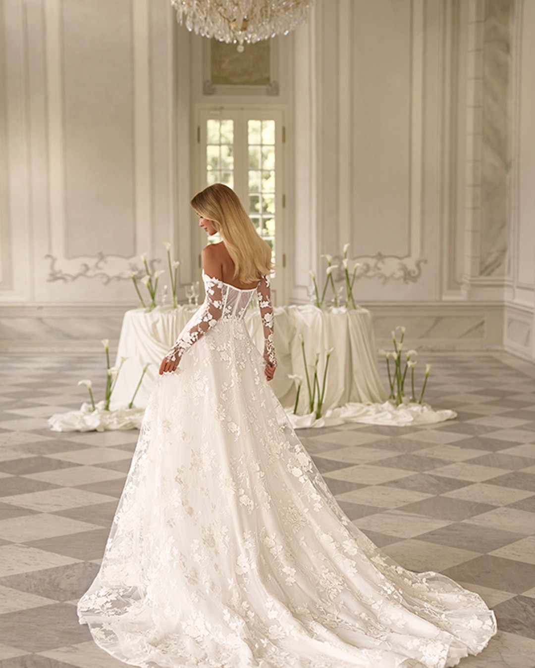 Subtelna suknia Reinbow zachwyca lekkością, romantycznymi kwiatowymi zdobieniami i nowoczesnym krojem w linii A. Gorsetowa góra, przezroczyste detale oraz opcjonalne rękawy tworzą stylową i kobiecą całość.