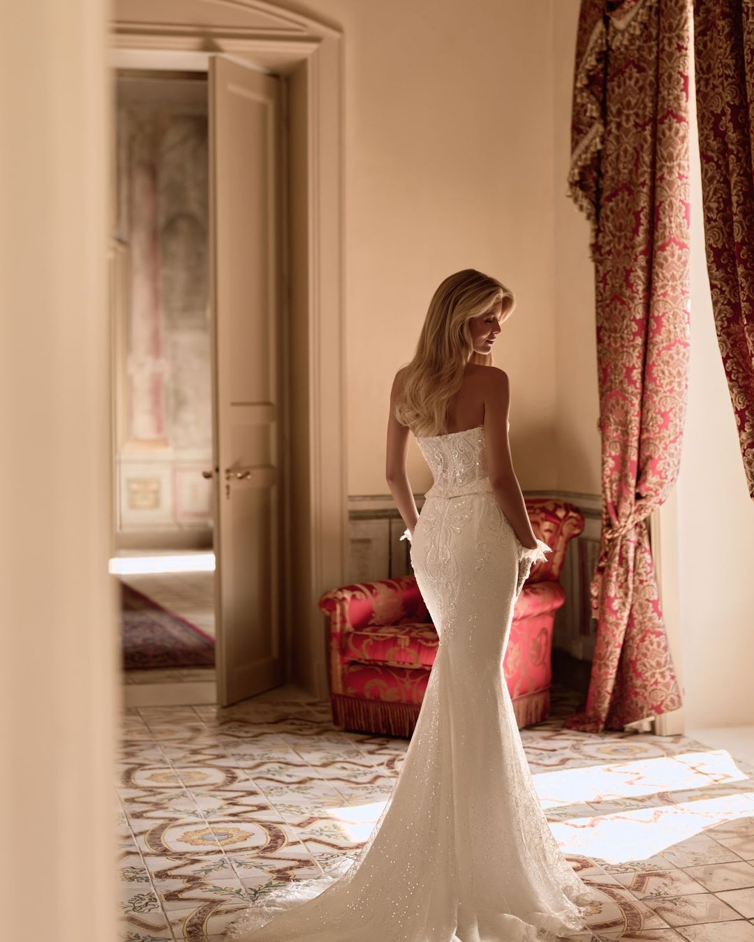 Model Zaphir od Anna Sposa to niezwykle elegancka i dopasowana suknia ślubna o nowoczesnym charakterze. Gorsetowa góra z baskinką i paskiem w literę V subtelnie modeluje talię, a całość wykonana z luksusowej francuskiej koronki nadaje kreacji unikalnego stylu. Tuba o dwuczęściowym efekcie podkreśla sylwetkę, a detale, jak choker i rękawiczki, dodają klasy i oryginalności.