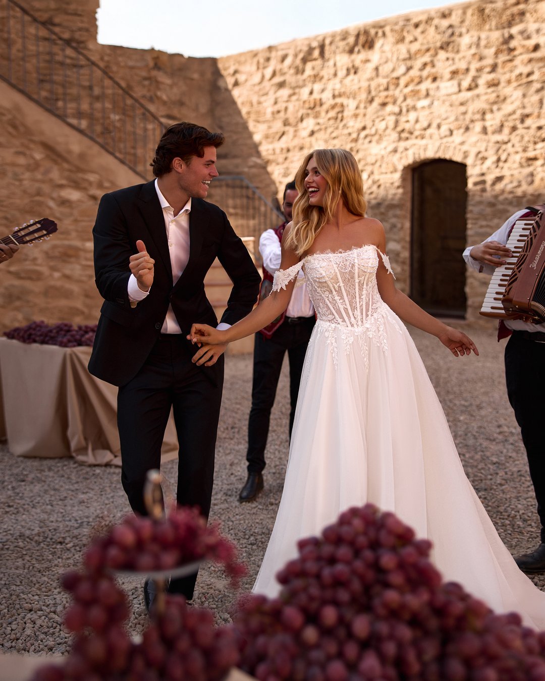 Suknia ślubna Horolina z kolekcji AnnaSposa to romantyczna propozycja dla przyszłych panien młodych pragnących połączyć elegancję z subtelnością. Wykonana z lekkiego tiulu i francuskiej koronki, zachwyca rozkloszowanym krojem, gorsetowym wykończeniem oraz delikatnymi opadającymi ramiączkami, które podkreślają sylwetkę. Efektowne kryształki oraz rozcięcie w stylu V dodają całości blasku, a długi tren wprowadza nutę spektakularności w tym niezapomnianym dniu.