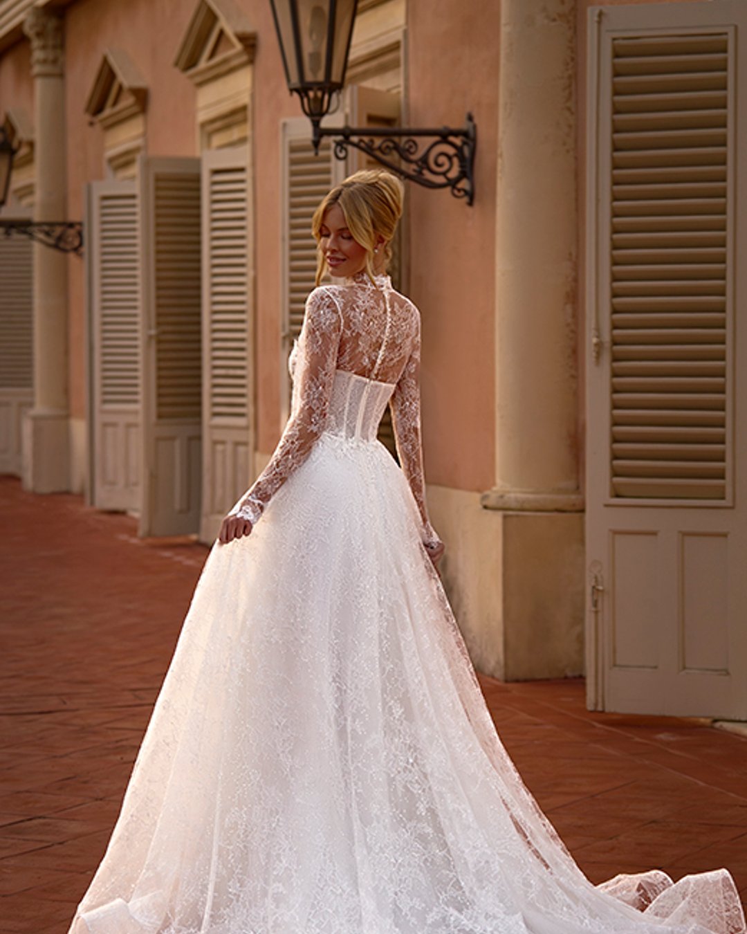 Elegancka suknia ślubna Lazurina zachwyca romantyczną linią A, pełną koronkowych detali i subtelnego blasku. Gorsetowy fason w połączeniu z dopinanym bolerkiem tworzy efektowną, a zarazem delikatną stylizację. To idealna propozycja dla Panny Młodej, która ceni klasykę w nowoczesnym wydaniu...