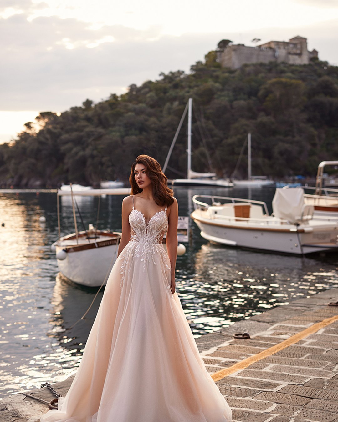 Anna Sposa – Model Varma to lekka suknia A-line z ręcznie zdobioną koronką, subtelnym rozcięciem i delikatnym trenem. Romantyzm i elegancja w jednym!
