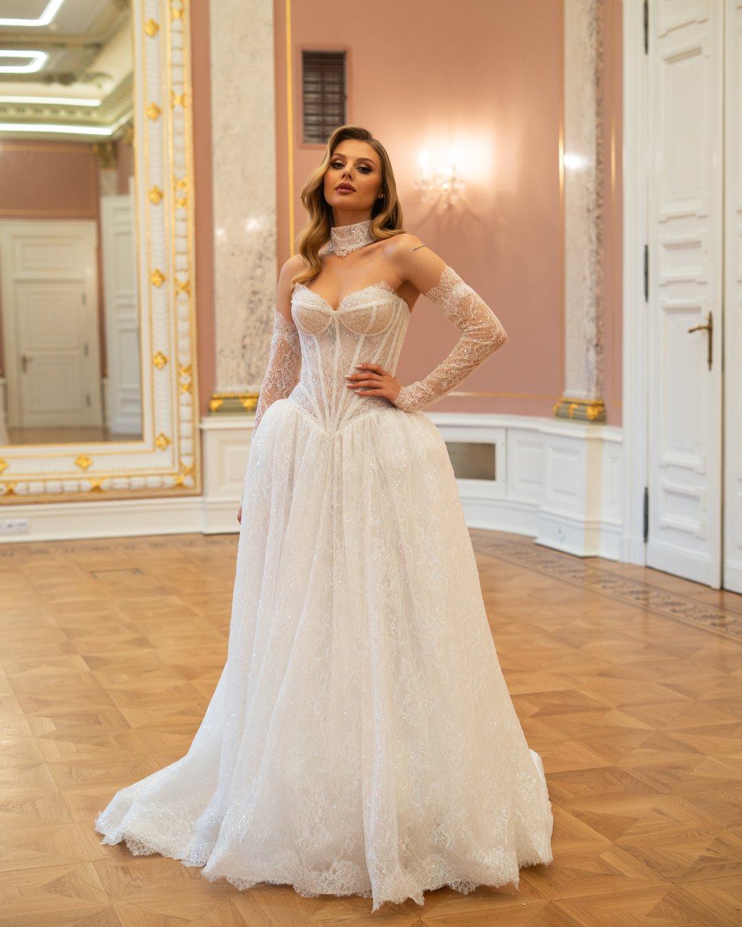 Suknia ślubna Lora z kolekcji LaLiven to prawdziwy symbol nowoczesnej elegancji, łączący w sobie styl princessy i linię A. Jej zachwycający gorset ozdobiony francuską koronką podkreśla sylwetkę, a delikatne, nakładane rękawki dodają subtelności. Długi tren sprawia, że każda panna młoda poczuje się niczym królowa w dniu swojego ślubu.