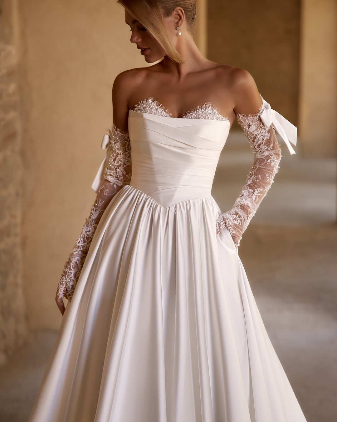 Suknia ślubna Frantelia z kolekcji AnnaSposa to kwintesencja klasycznej elegancji, która zachwyca zarówno gorsetowym krojem, jak i rozkloszowanym dołem, idealnie podkreślającym sylwetkę. Dekolt w kształcie serca oraz subtelne perły dodają jej niepowtarzalnego blasku, a tren nadaje całości romantycznego charakteru. Wybierz Frantelię, aby w dniu swojego ślubu poczuć się jak prawdziwa księżniczka.