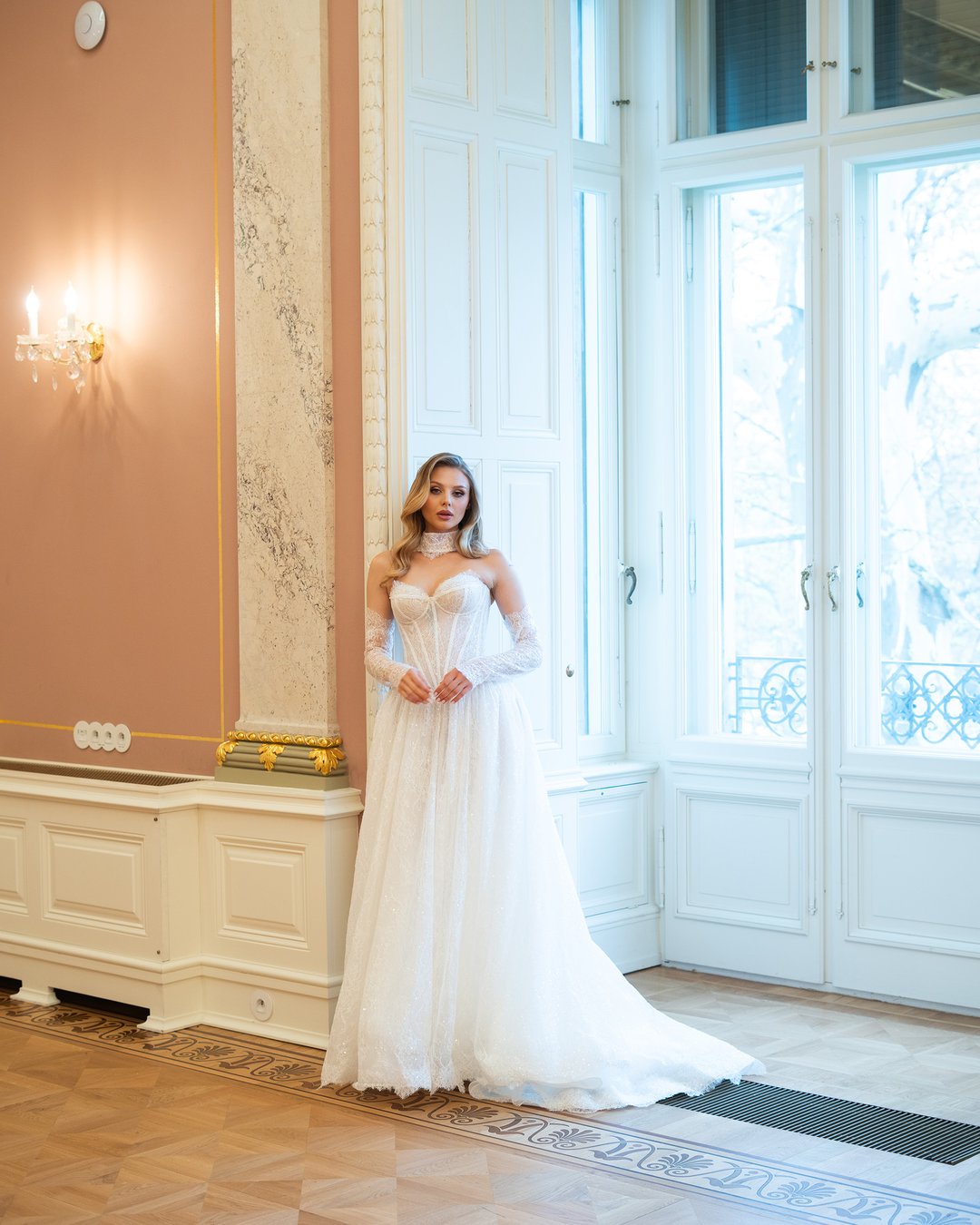 Suknia ślubna Lora z kolekcji LaLiven to prawdziwy symbol nowoczesnej elegancji, łączący w sobie styl princessy i linię A. Jej zachwycający gorset ozdobiony francuską koronką podkreśla sylwetkę, a delikatne, nakładane rękawki dodają subtelności. Długi tren sprawia, że każda panna młoda poczuje się niczym królowa w dniu swojego ślubu.