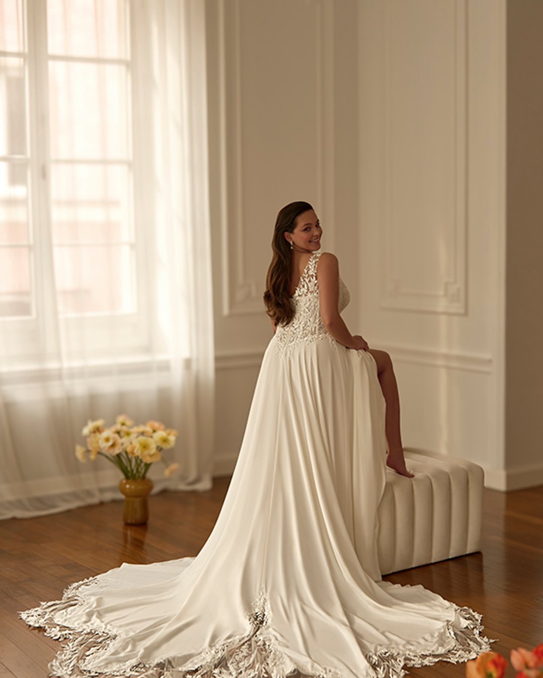 Model Shimella to klasyczna suknia ślubna o kroju linii A, z elegancką koronkową górą i zwiewną muślinową spódnicą. Przezroczysty gorset z szerokimi ramiączkami i pasem w literę V pięknie podkreśla talię i zapewnia komfort oraz subtelną elegancję.