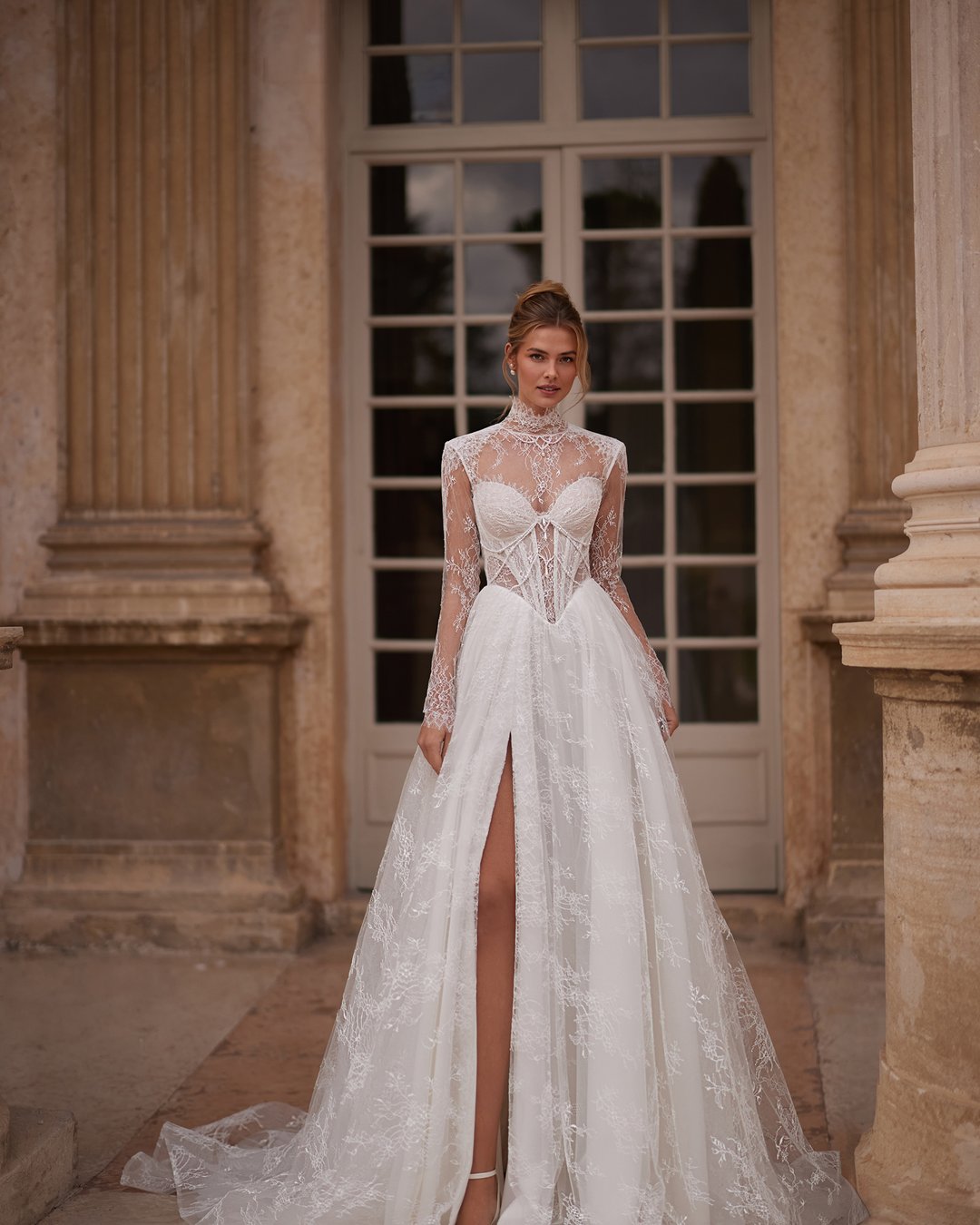 Suknia Kaviella z kolekcji AnnaSposa to połączenie elegancji i nowoczesności, które zachwyci każdą pannę młodą. Wykonana z delikatnej francuskiej koronki, z zmysłowym rozporkiem i gorsetowym krojem, subtelnie podkreśla sylwetkę, a przezroczyste szerokie ramiączka dodają jej lekkości. Uzupełniona o bolerko i efektowny tren, ta suknia sprawi, że poczujesz się wyjątkowo w najważniejszym dniu swojego życia.