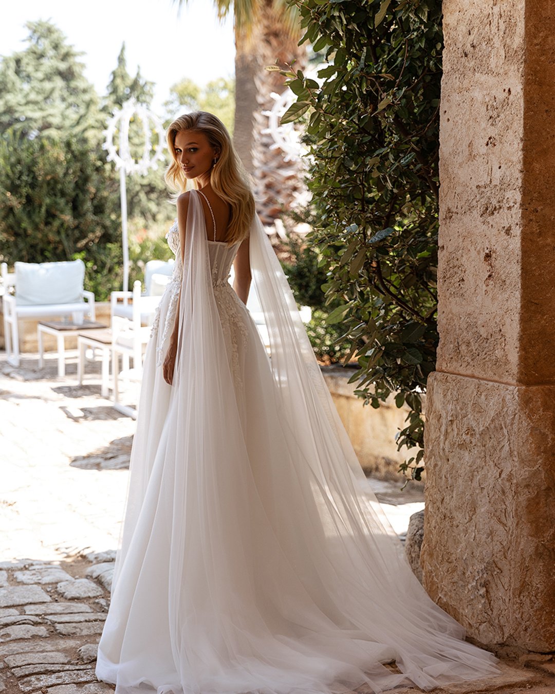 Model Avva, wykonana z lekkiego tiulu i koronki, o kroju litery A z kwiatkami 3D i trenem. Idealna dla panny młodej szukającej elegancji i subtelności.