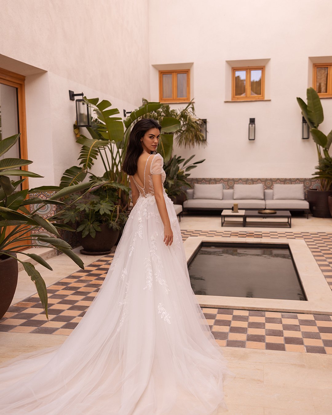 Delikatna suknia o linii A z koronkowym gorsetem ozdobionym kwiatowymi aplikacjami, krótkimi rękawkami z tiulu i lekką spódnicą, idealna na romantyczny ślub.