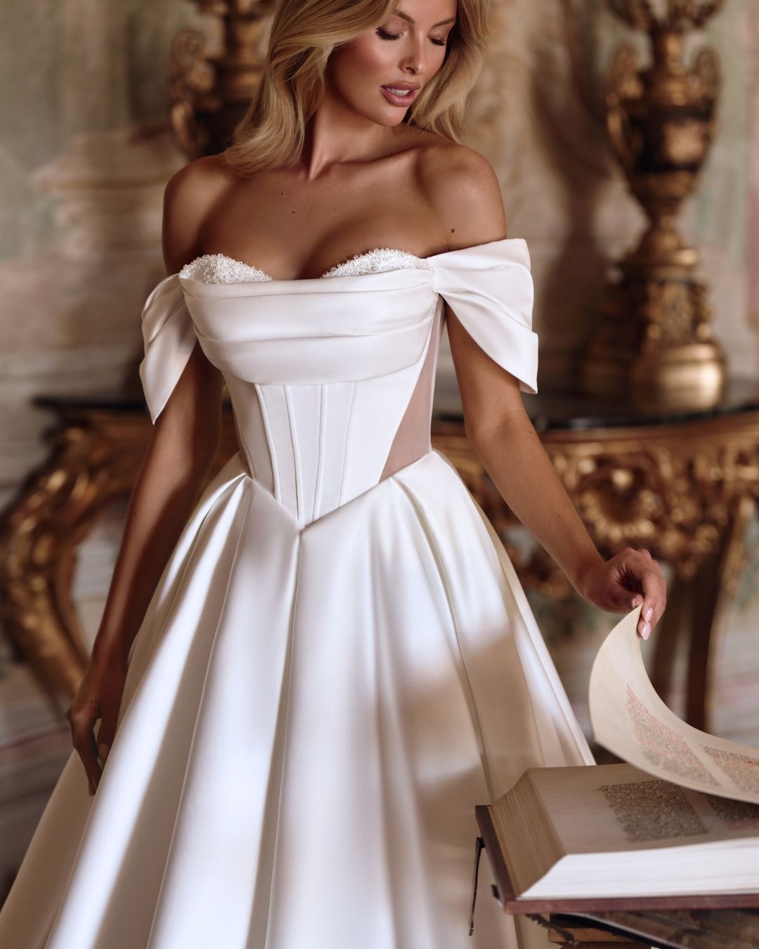 Suknia Toya to wyjątkowa propozycja od Anna Sposa dla miłośniczek klasycznej elegancji. Gładka, wykonana z luksusowej satyny, posiada gorsetowy fason z opadającymi ramiączkami i transparentnymi wstawkami, które dodają subtelnej zmysłowości. Całość uzupełniają błyszczące kryształki, przezroczyste plecy oraz efektowny rozporek.