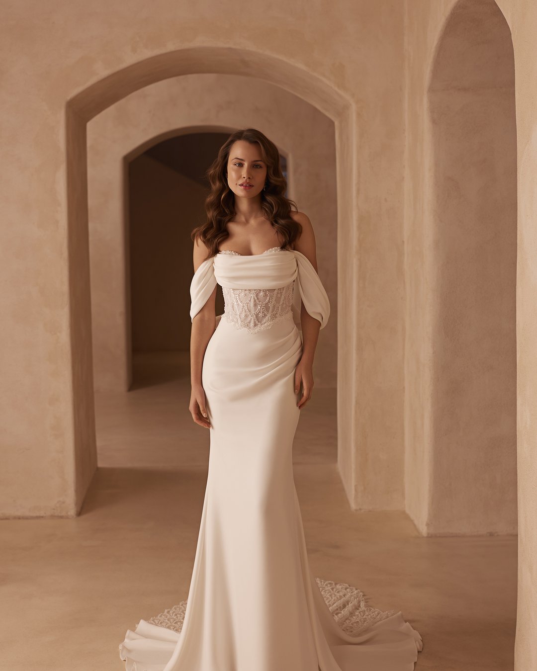 Suknia ślubna 5859 z kolekcji Elizabeth Passion to kwintesencja klasycznej elegancji, łącząca nowoczesny design z ponadczasowym stylem. Delikatne opadające ramiączka oraz zjawiskowy tren podkreślają smukłą sylwetkę, a gorsetowa, dopasowana konstrukcja z satyny i koronki emanuje blaskiem i subtelnym wdziękiem. To idealny wybór dla panien młodych, które pragną wyglądać olśniewająco w dniu swojego ślubu.