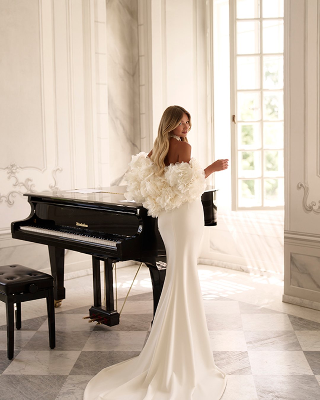 Suknia Uliana od Anna Sposa to esencja współczesnej elegancji z nutą klasyki. Gładka, dopasowana linia z wyraźnym pasem w literę V i gorsetowym topem pięknie podkreśla sylwetkę. Subtelne perełki przy dekolcie oraz spektakularne bolerko z kwiatowymi aplikacjami dodają szyku i oryginalności. To propozycja dla panny młodej, która ceni sobie minimalizm, ale nie boi się wyrazistych detali.