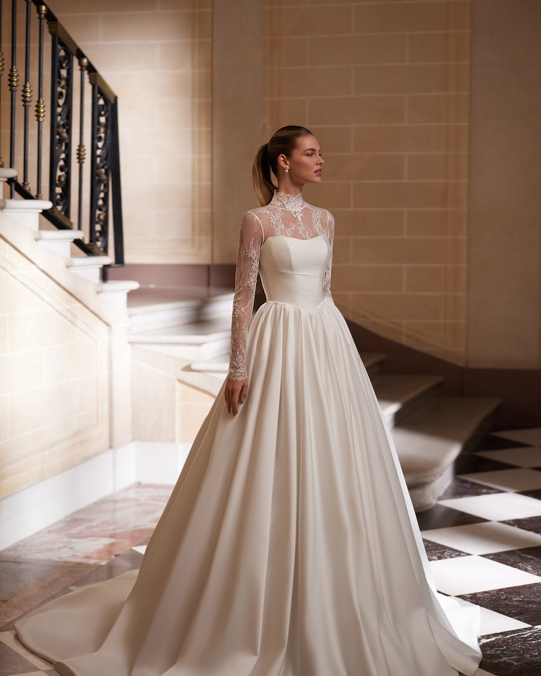 Suknia ślubna Diamora z kolekcji AnnaSposa to doskonały wybór dla przyszłych panien młodych pragnących połączyć klasykę z elegancją. Jej gorsetowy krój z dekoltem na prosto oraz efektownym trenem tworzy zjawiskową sylwetkę w stylu princessy, a delikatne nakładane bolerko dodaje romantycznego uroku. Wykonana z luksusowej francuskiej koronki, sukienka ta z pewnością uczyni Twój wyjątkowy dzień niezapomnianym.