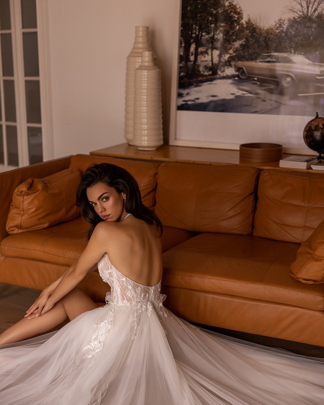 Suknia Elizabeth Passion o linii A z głębokim dekoltem, koronkowymi detalami, piórami oraz efektownym rozcięciem na nogę. Z tyłu zapinana na szyję, idealnie podkreślająca sylwetkę.