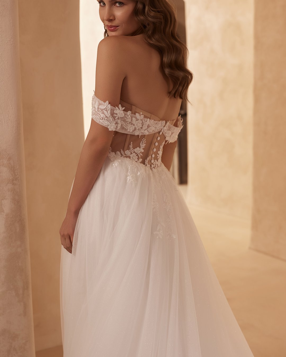 Suknia ślubna 5816 z kolekcji Elizabeth Passion to kwintesencja nowoczesnej elegancji, łącząca w sobie zmysłowość i delikatność. Jej szeroka spódnica z tiulu, ozdobiona koronkowymi detalami, doskonale współgra z gorsetowym topem i opadającymi ramiączkami, a subtelny rozporek dodaje całości odrobiny śmiałości. Pas w kształcie litery V podkreśla talię, tworząc sylwetkę, która oczaruje w tym wyjątkowym dniu.