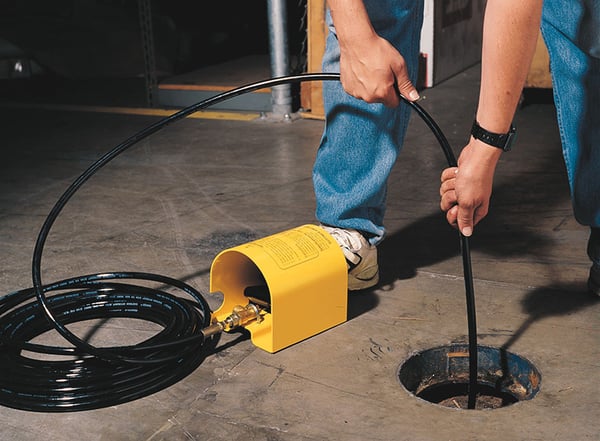 Man Using Suttner Foot Controlled Pressure Valve to Feed Sewer Hose Down Drain