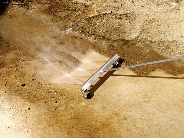 Water Broom Clearing Dirt from Concrete