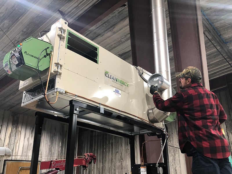 Northstar technician installing a waste oil heater on a Clean Energy stack kit.