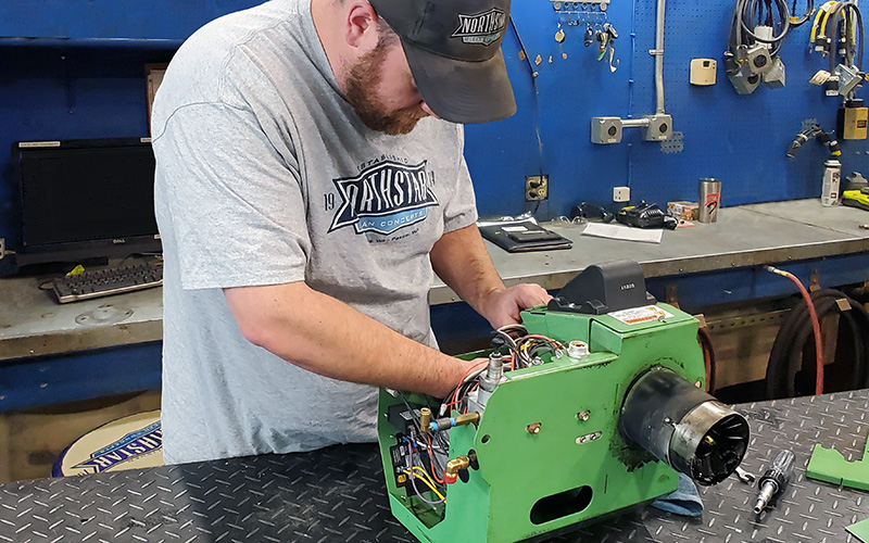 Northstar technician preforming maintenance on a waste oil burner