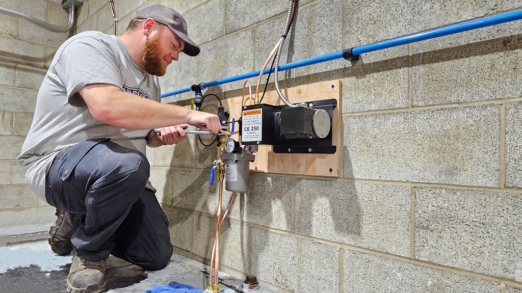 Northstar technician performing maintenance on a waste oil pump